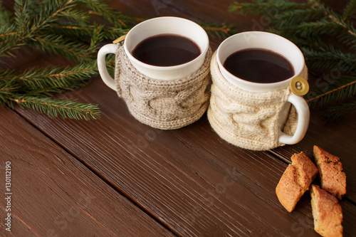 Cup of coffee with knitted cup holder on wooden background with copy space. Love morning coffee 