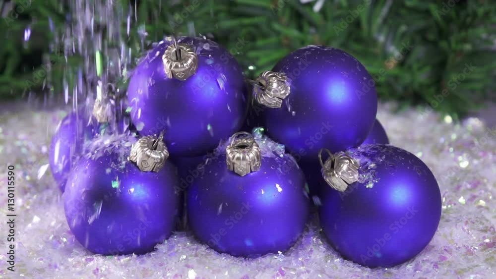Snow slowly falls on New Year's balls against the background of a Christmas fir-tree. slow motion Snow slowly falls on New Year's balls against the background of a Christmas fir-tree. slow motion