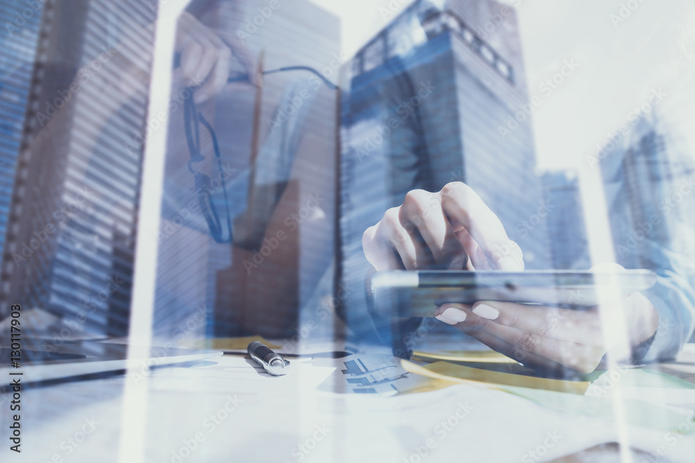Closeup view of female hands touching screen digital tablet.Concept business people using mobile gadgets.Double exposure,modern skyscraper office building on blurred background.Horizontal. Closeup view of female hands touching screen digital tablet.Concept business people using mobile gadgets.Double exposure,modern skyscraper office building on blurred background.Horizontal.