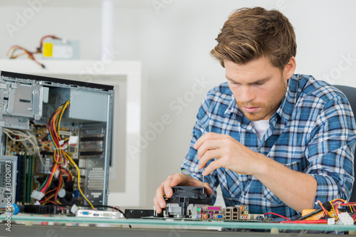 Wallpaper Mural young man fixing computer Torontodigital.ca