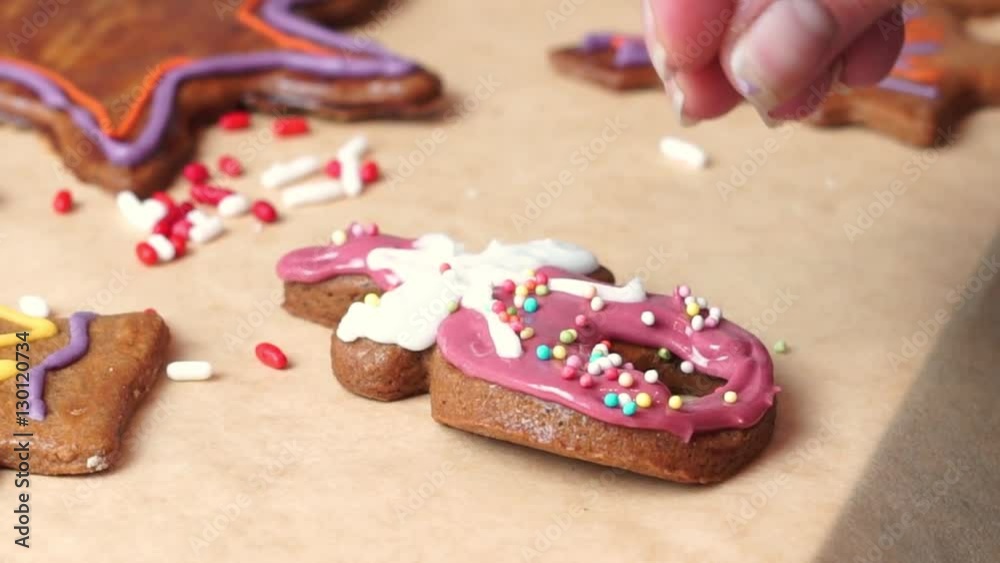women decorating gingerbread with edible sugar sprinkles women decorating gingerbread with edible sugar sprinkles