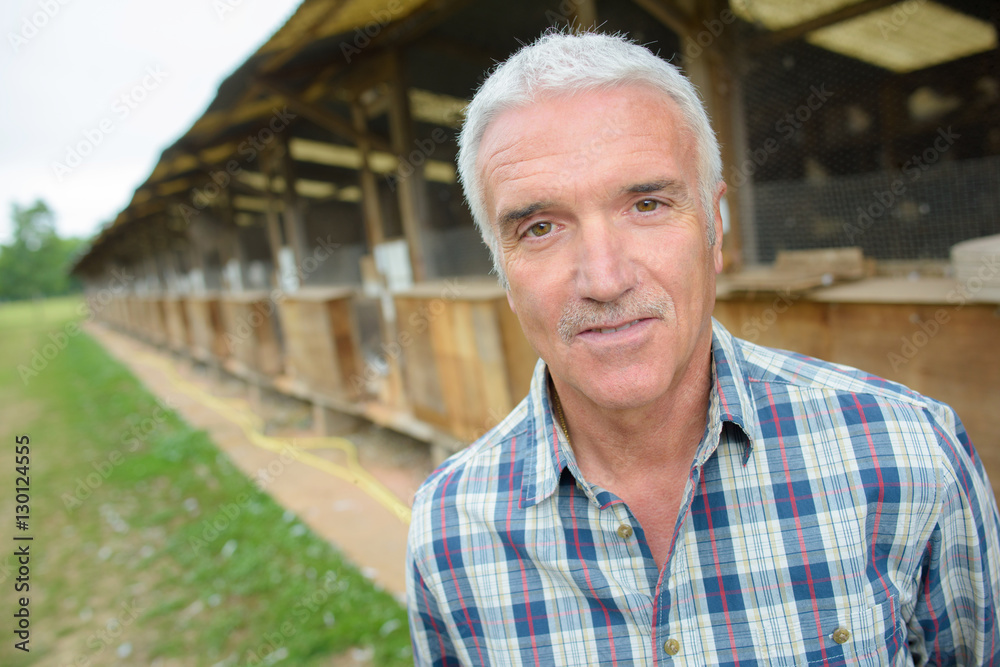 Portrait of mature man by aviary Portrait of mature man by aviary