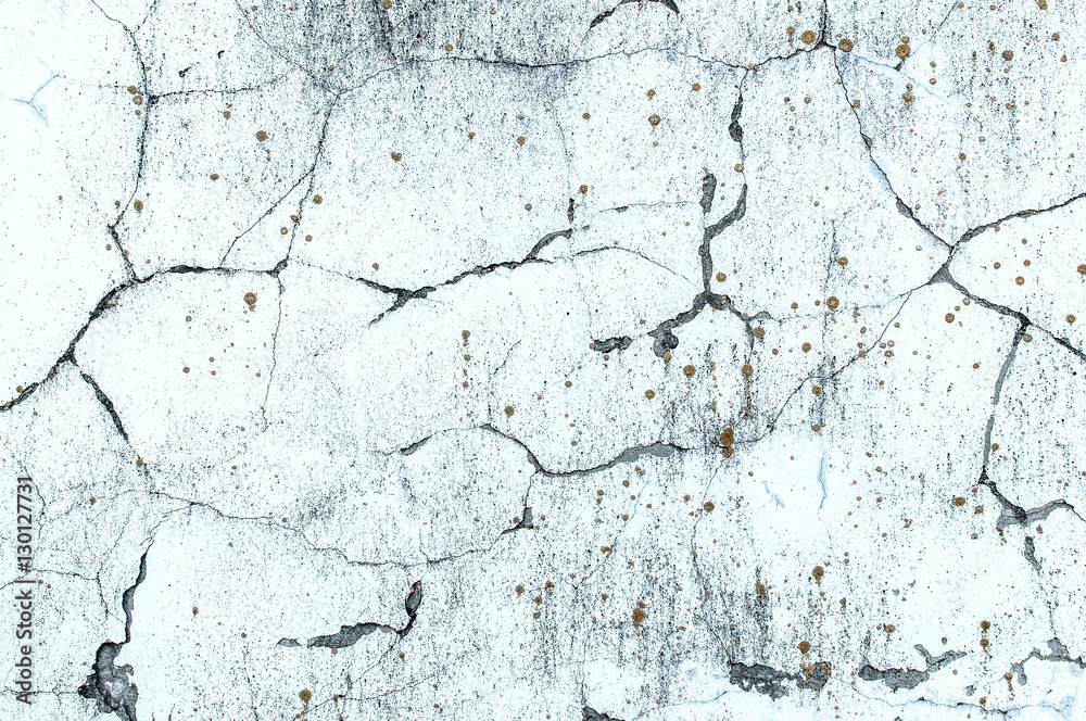 Texture of whitewashed concrete wall with cracks and spots of lichen