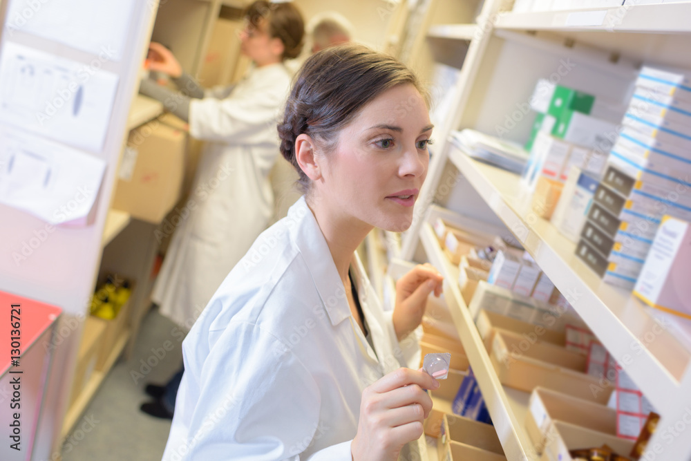 Pharmacist scanning shelf