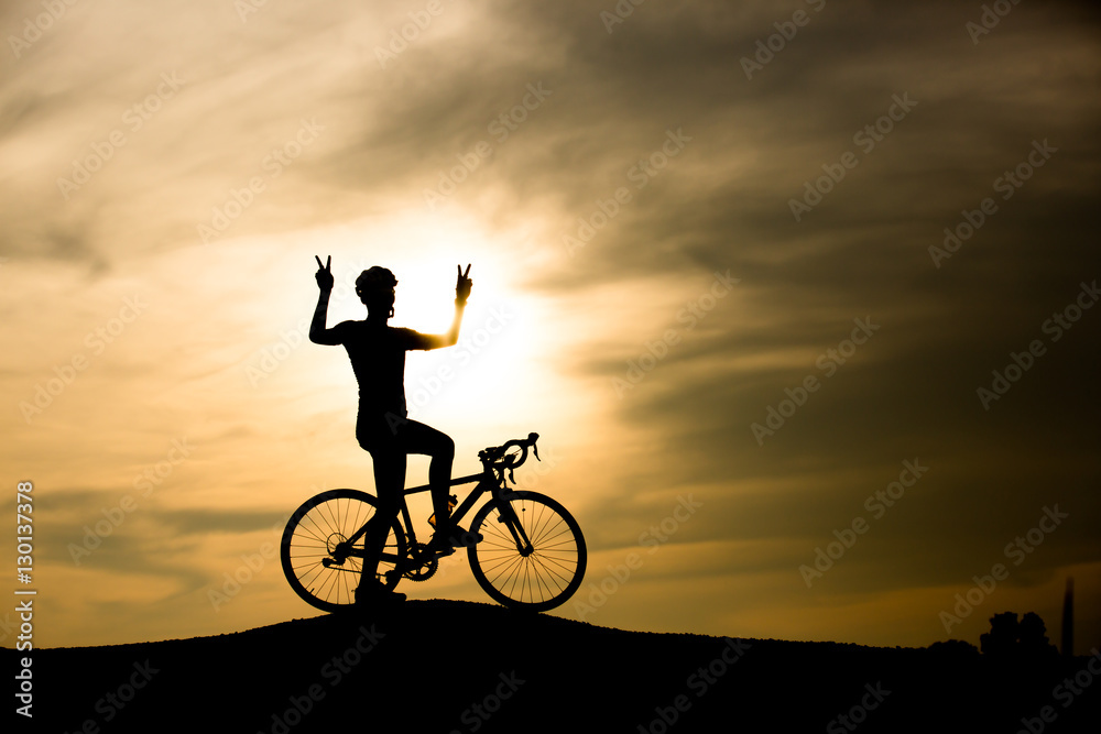 Fototapeta premium Silhouette of man with bicycle at sunset
