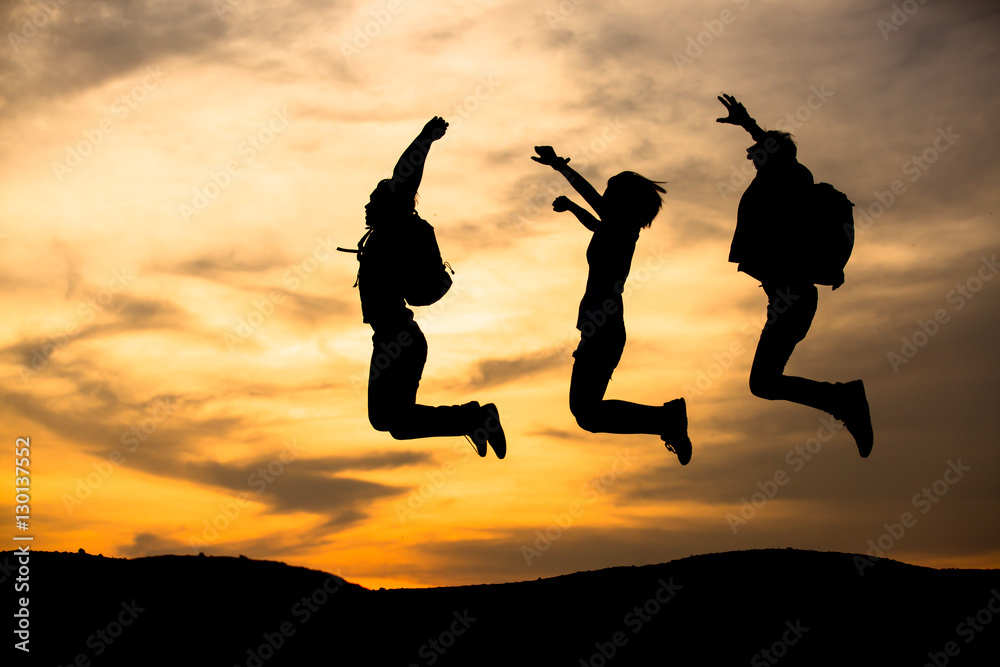 silhouette of friends jumping in sunset silhouette of friends jumping in sunset