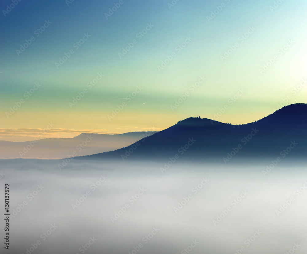 Majestic fog ocean in the mountains on sunset