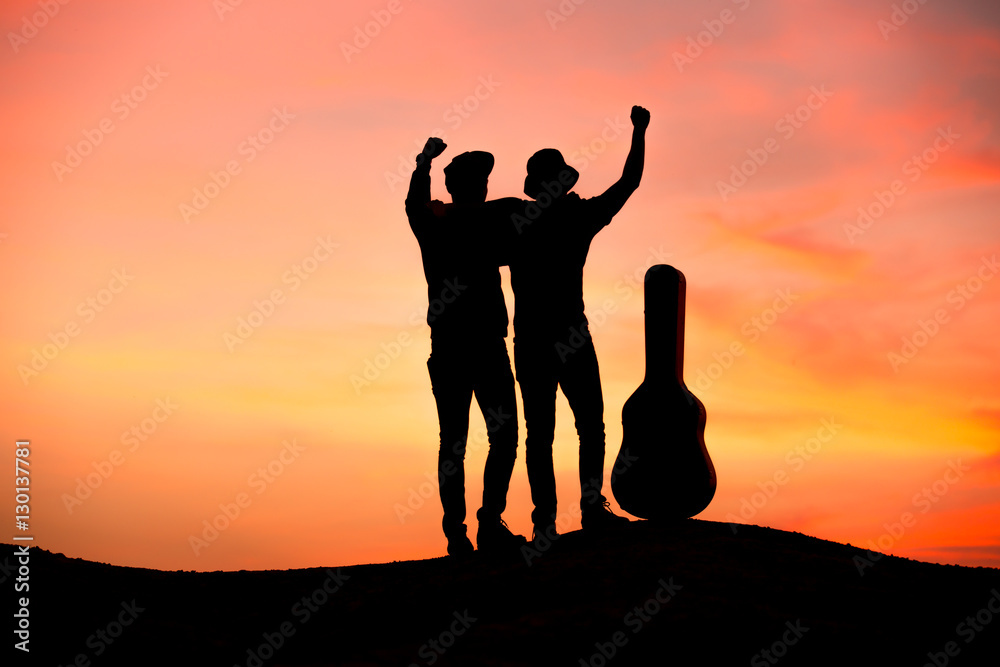 Fototapeta premium silhouette of musician with guitar at sunset