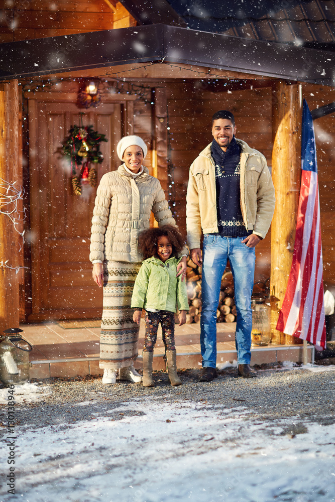 Fototapeta premium young family front wooden house on winter day