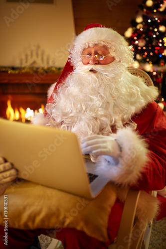 Real Santa Claus using laptop to communicating with children