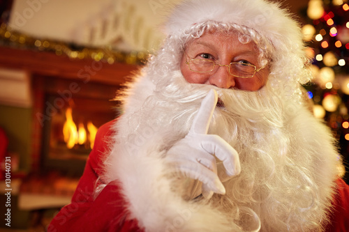 Santa holding a finger to his mouth photo