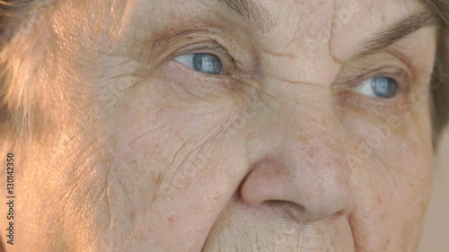 Elderly woman's face with tired expression of face. Close up photo