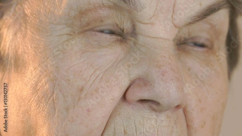 Old woman's face with tired expression of face. Close up photo