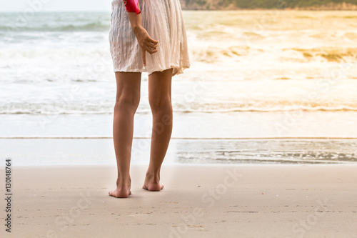 Low angle behind woman walking barefoot on beach © saelim