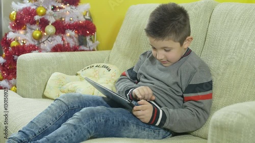 boy playing with his new tablet, christmas gift photo