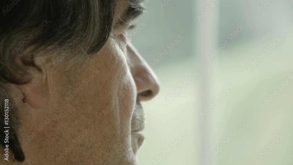 grizzled hair man looking pensively out of the window grizzled hair man looking pensively out of the window