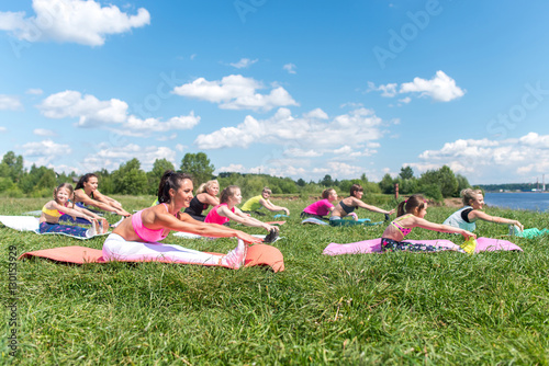 Fit women doing exercises stretching hamstrings fitness class in parkland © undrey