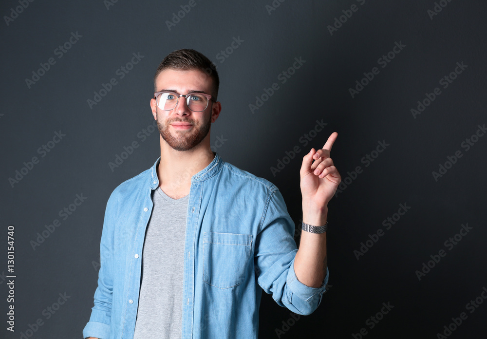Portrait of a smiling young man pointing up Portrait of a smiling young man pointing up