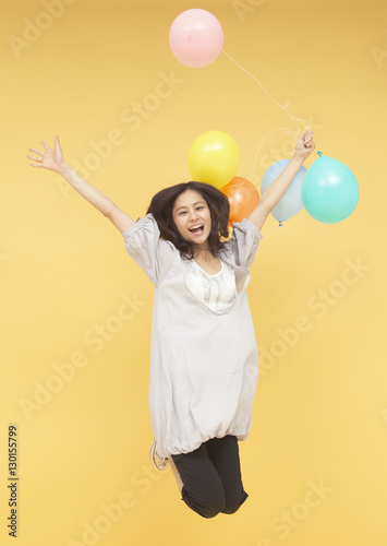 Young woman holding balloons © imagenavi