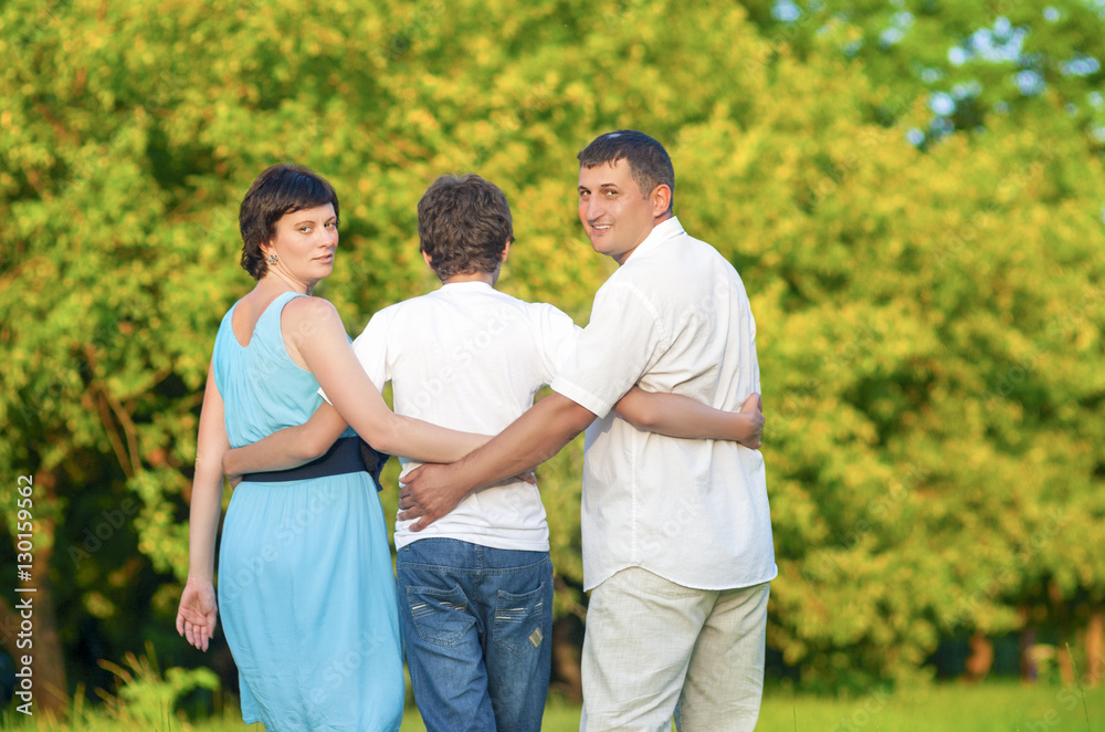 Love and Tenderness Concepts and Ideas. Caucasian Family of Three Having a Stroll In Summer Forest Love and Tenderness Concepts and Ideas. Caucasian Family of Three Having a Stroll In Summer Forest