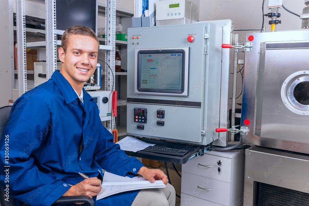 Smiling engineer working with the equipment in the science laboratory