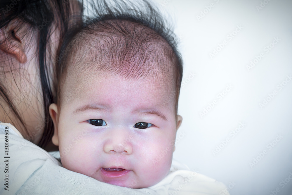 Mother and baby, Lovely asian girl resting on her mother's shoulder Mother and baby, Lovely asian girl resting on her mother's shoulder