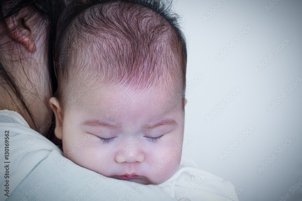 Mother and baby, Lovely asian girl resting on her mother's shoulder Mother and baby, Lovely asian girl resting on her mother's shoulder