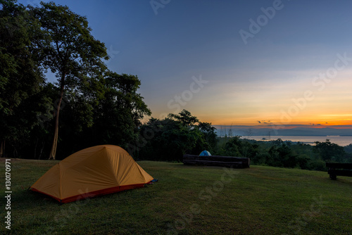 Tourist tent in camp among meadow in the mountain at sunrise