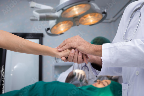 Hand of doctors to reassuring relatives of the patient