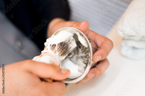 Barber preparing shaving foam with a brush
