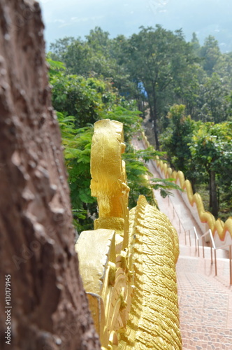 high stairway through the wood up to Buddhist temple on mountain photo