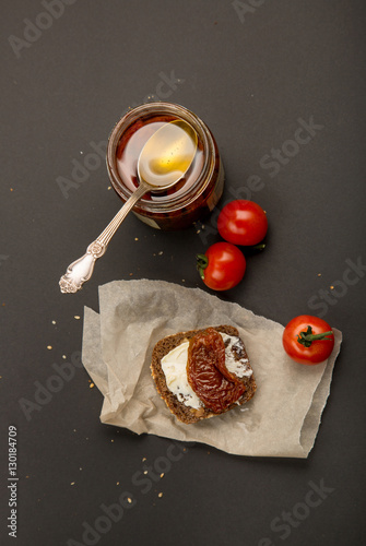 piece of black bread with butter and sun dried tomato
