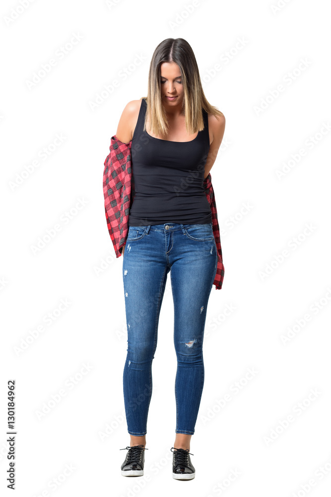 Foto Stock Young woman wearing jeans taking off red checkered plaid shirt  looking down. Full body length standing portrait isolated over white  background. | Adobe Stock