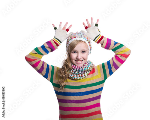 Cute cheerful teenage girl wearing colorful striped sweater, scarf, gloves and hat isolated on white background. Winter clothes. Composite image.