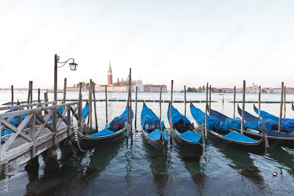 Gondolas moored on the Lagoon, San Giorgio Maggiore beyond, Riva degli Schiavoni, Venice, Veneto Gondolas moored on the Lagoon, San Giorgio Maggiore beyond, Riva degli Schiavoni, Venice, Veneto