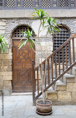 Courtyard of Beit El Set Waseela (Waseela Hanem House), with wooden closed door and window with interleaved wooden grid and stair with wooden handrail leading to the upper floor, Medieval Cairo, Egypt photo