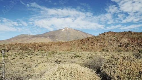 Hiking in Teide National Park. Footage of dramatic volcanic landscape with majetic Teide volcano in a background, Tenerife, Canary Islands, Spain. photo