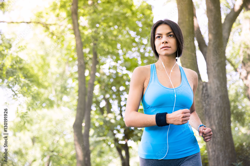 Fototapeta premium Sporty young woman running outdoors