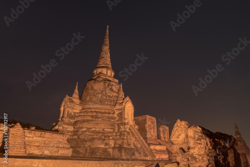 Ancient ruins of the temple Wat Phra Sri Sanphet national historic site with lights show at twilight time in Ayutthaya, Thailand.
