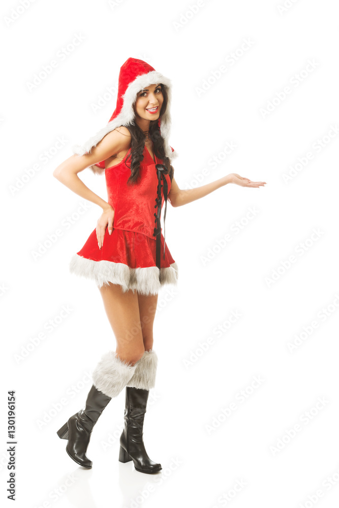 Full length woman holding something invisible in right hand wearing santa clothes Full length woman holding something invisible in right hand wearing santa clothes