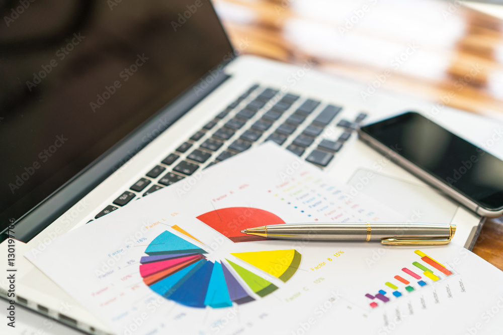 Financial charts on the table with laptop . Financial charts on the table with laptop .