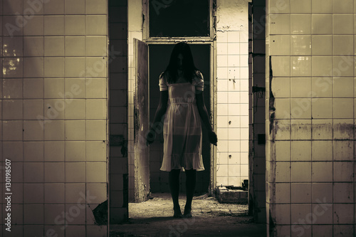 Horror scene of haunted woman in white dress in the demolished building