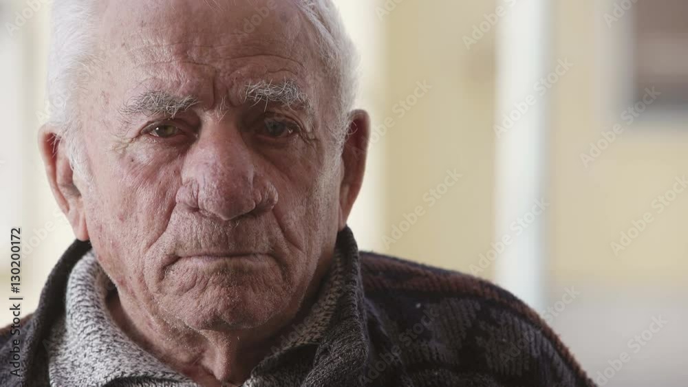 depressed old man looks to the camera