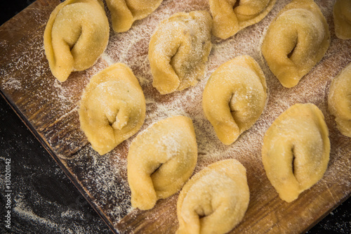 Freshly prepared Italian tortellini on wooden board  top view © allenkayaa