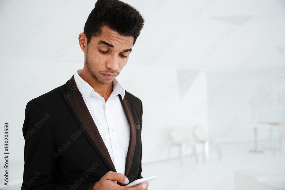 African business man writing message on phone