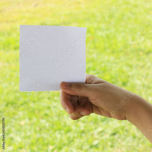 Woman hand holding note paper with space for text