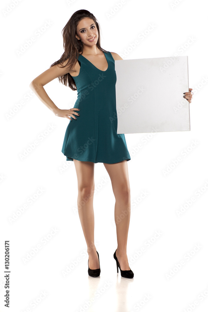 Fototapeta premium advertising young woman in a short turquoise dress holding empty banner
