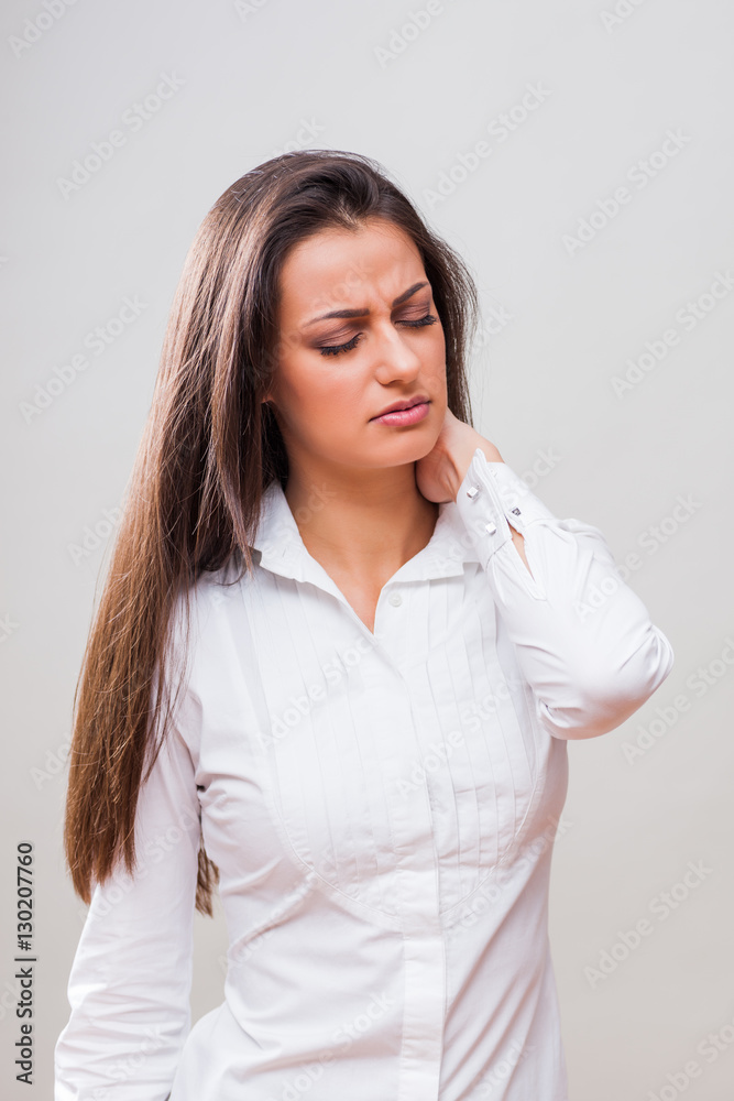 Portrait of young businesswoman who is having pain in her neck. Portrait of young businesswoman who is having pain in her neck.