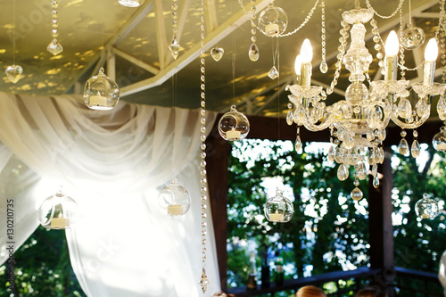 Crystal chains and balls with candles hang from the ceiling on p