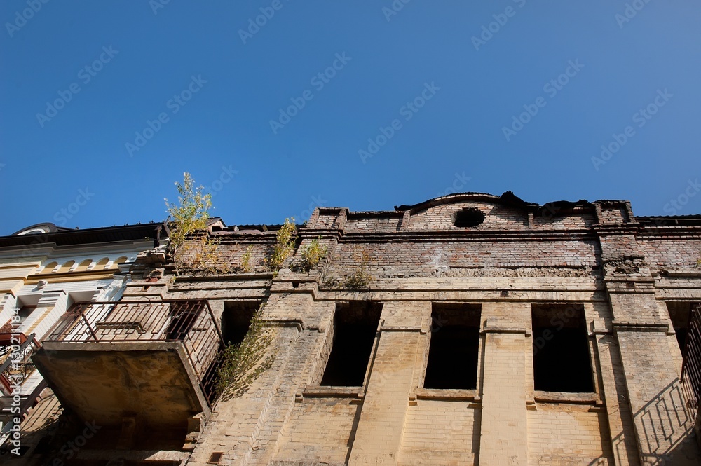 Abandoned uninhabited house with broken windows and overgrown with tree Abandoned uninhabited house with broken windows and overgrown with tree
